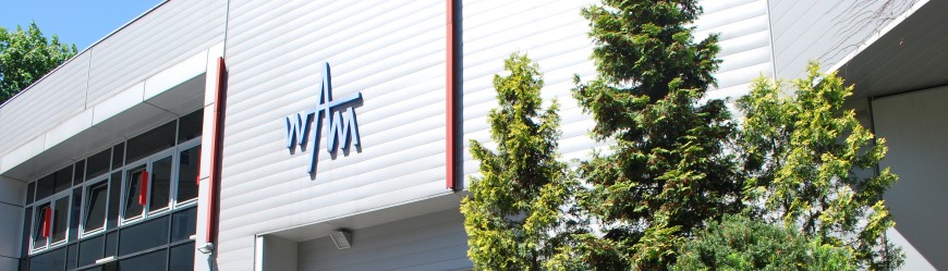 Logo Wydawnictwa WAM na ścianie budynku wielofunkcyjnego.