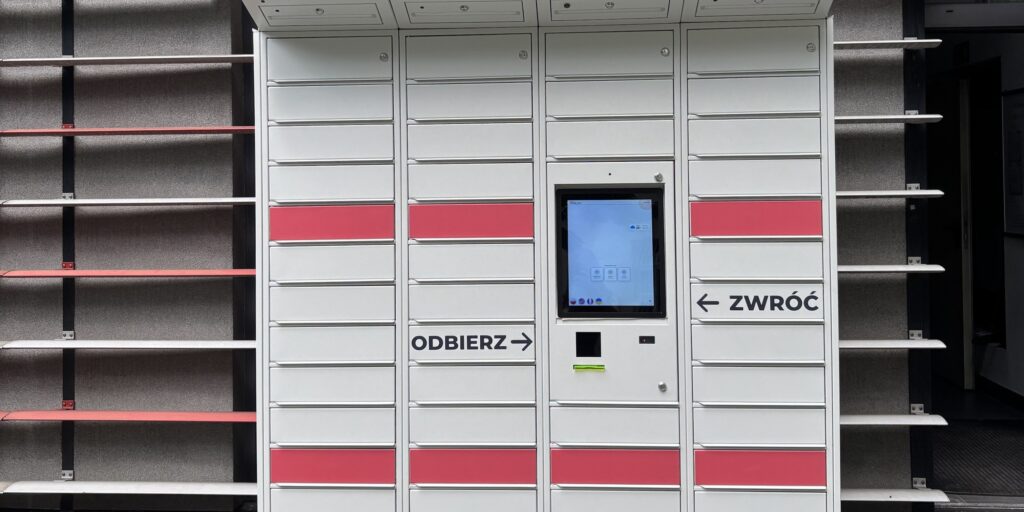 ksiazkomat Zdjęcie przedstawia książkomat znajdujący się przed budynkiem Biblioteki
